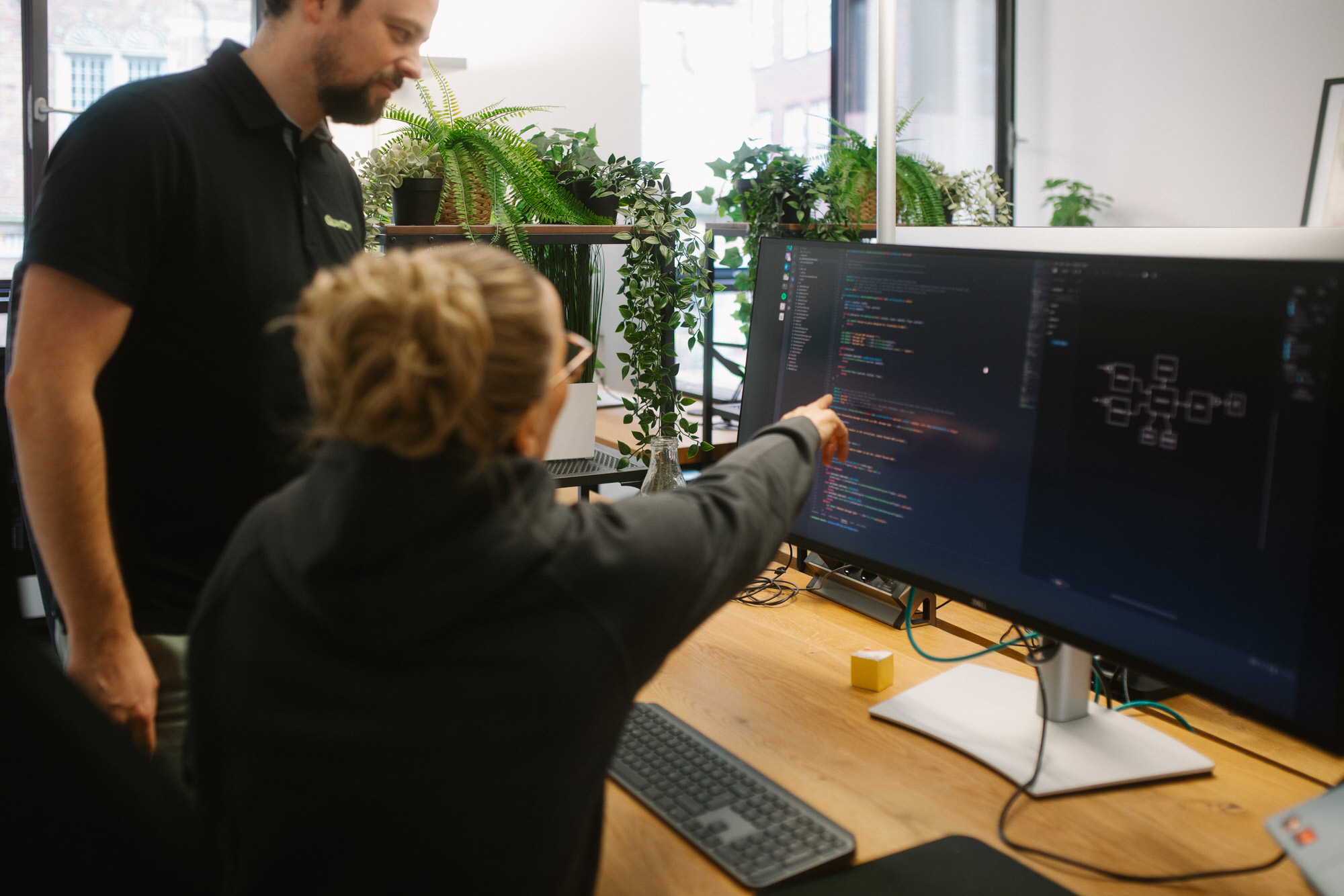 Eine Mitarbeiterin und Geschäftsführer Tom Tapken besprechen ein Projekt am Computer